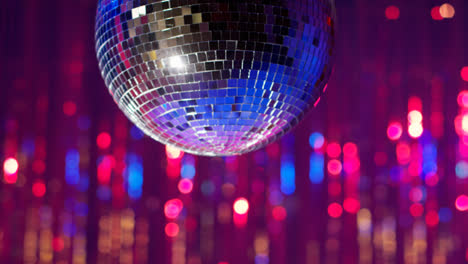 Close-Up-Of-Mirrorball-Slowly-Revolving-In-Night-Club-Or-Disco-With-Sparkling-Lights-In-Background-1